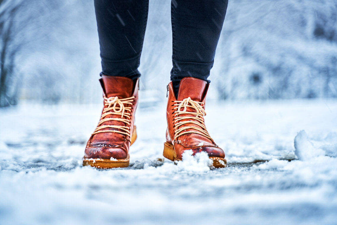 Feet wearing boots standing on the snowy ground