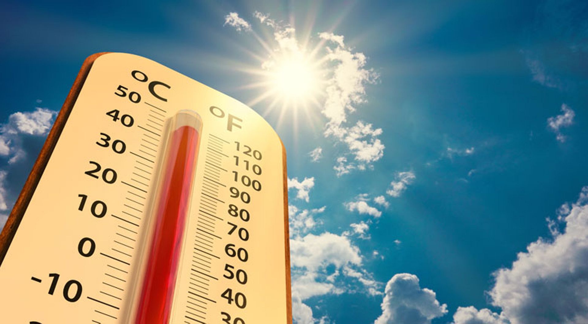 Image of a thermometer showing high temperature with a bright sun in the background.