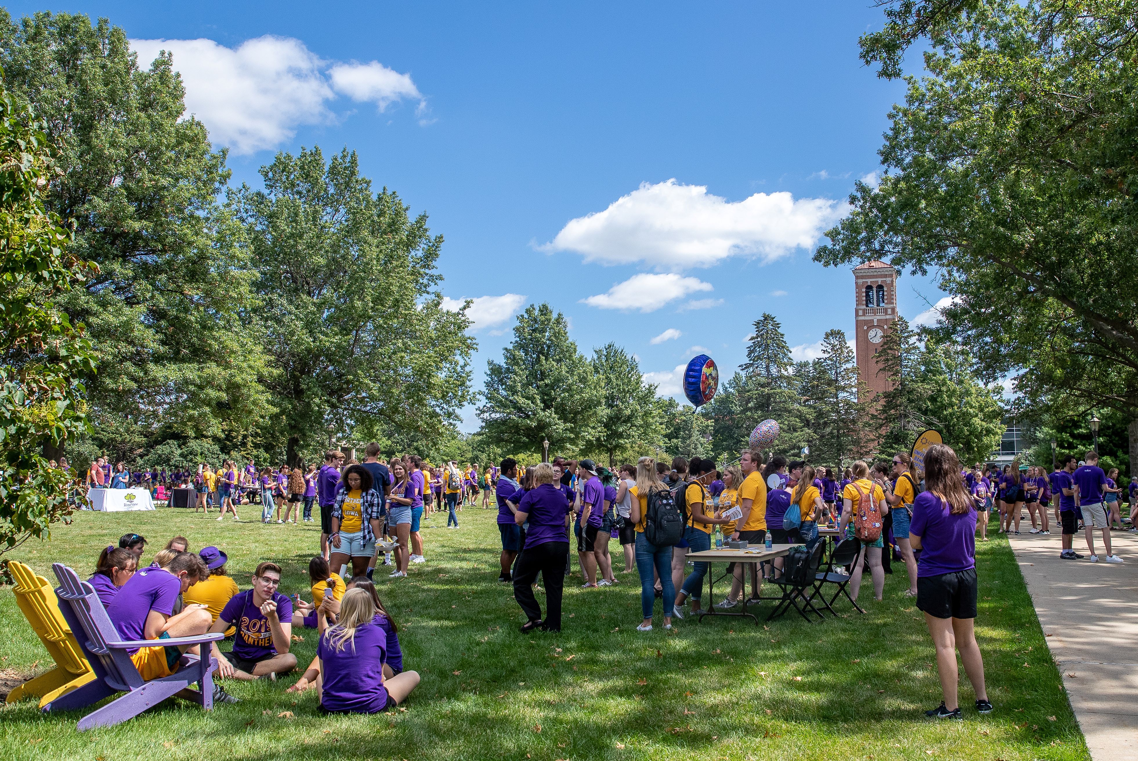 Campus community gathering on lawn by Campanile.